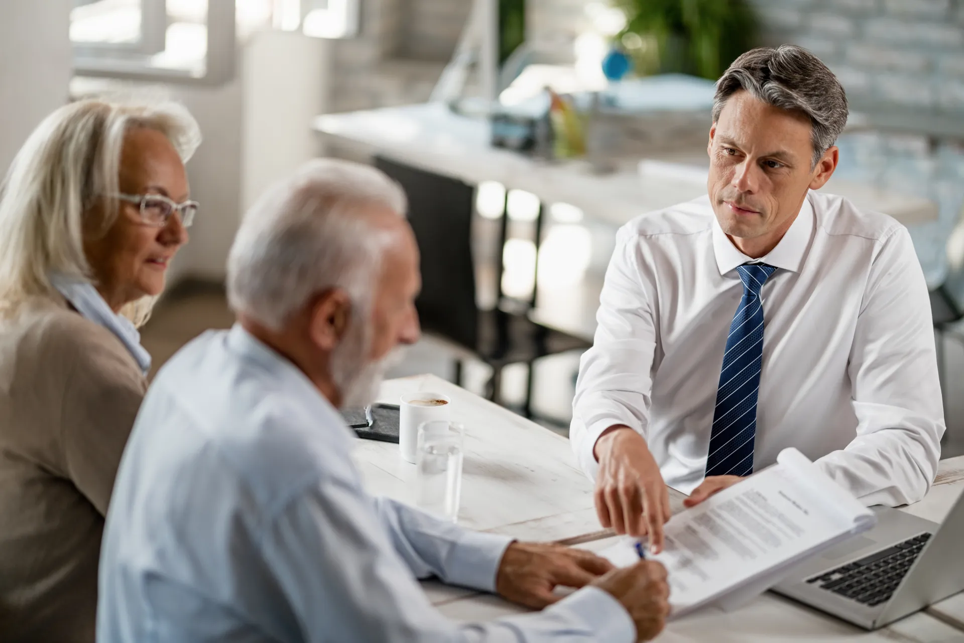 bank-manager-having-meeting-with-senior-couple-pointing-place-they-need-sign-contract