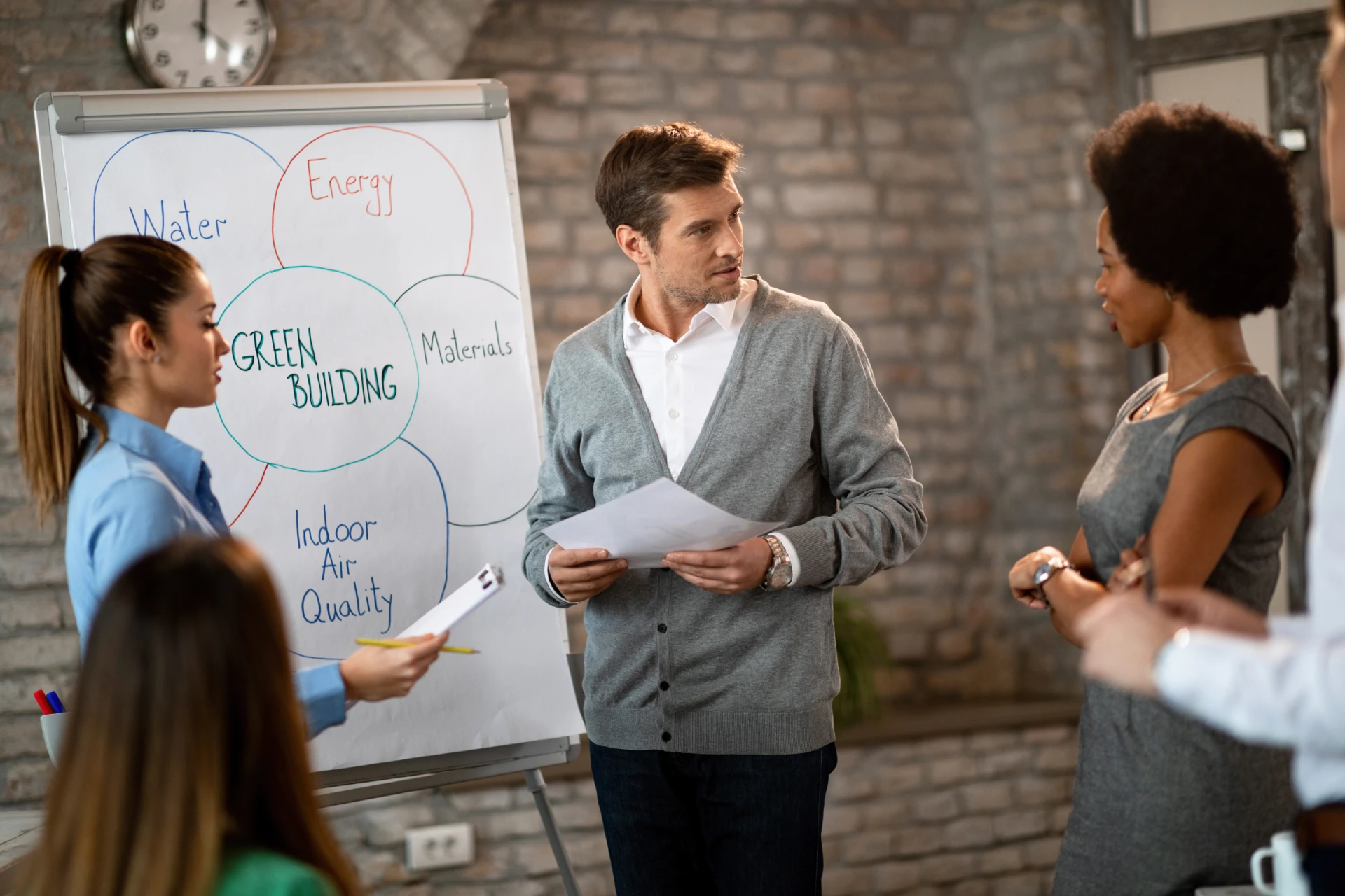 mid-adult-businessman-his-colleagues-brainstorming-front-whiteboard-while-working-new-business-strategy-office