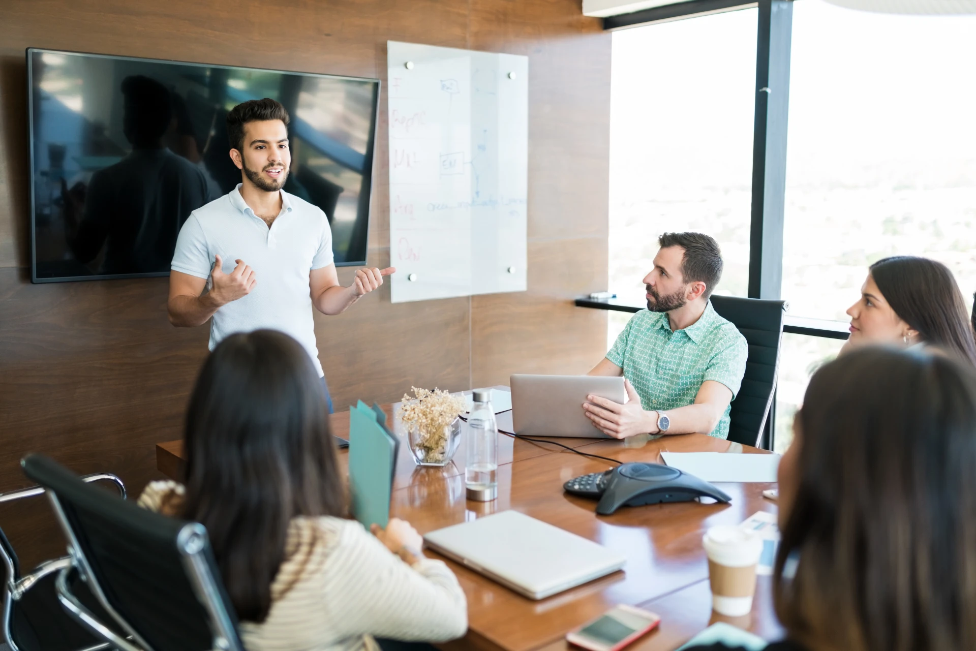 young-hispanic-presenter-explaining-business-plan-coworkers-meeting-room