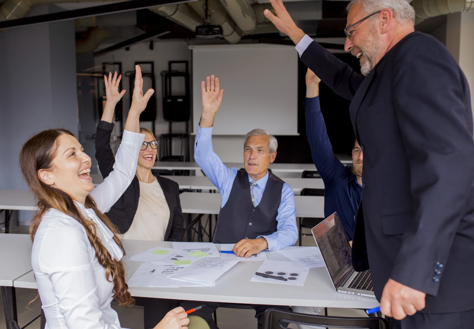 happy-successful-businesspeople-raising-their-hands-board-meeting