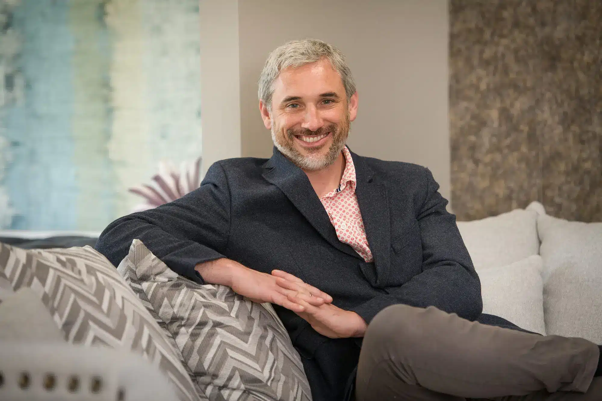 Richard Reid sitting relaxed and smiling on a sofa